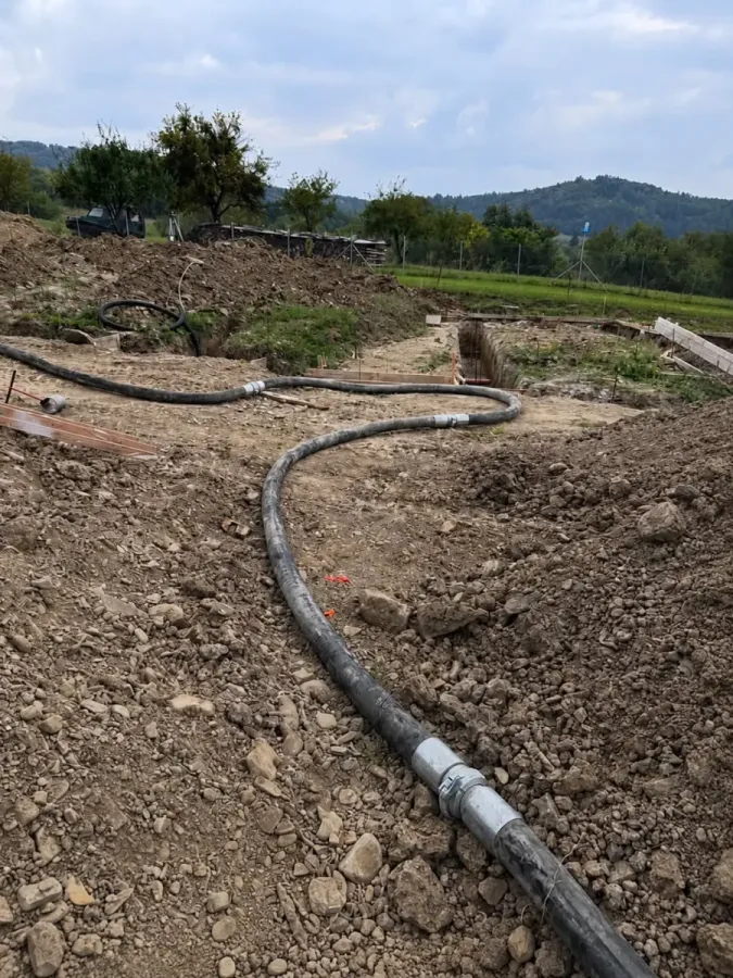 Dlhé potrubie čerpadla vedené cez stavenisko k miestu betonáže